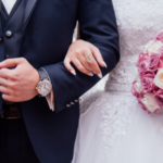 a photo of a bride and groom arm and arm, with just their torso visible